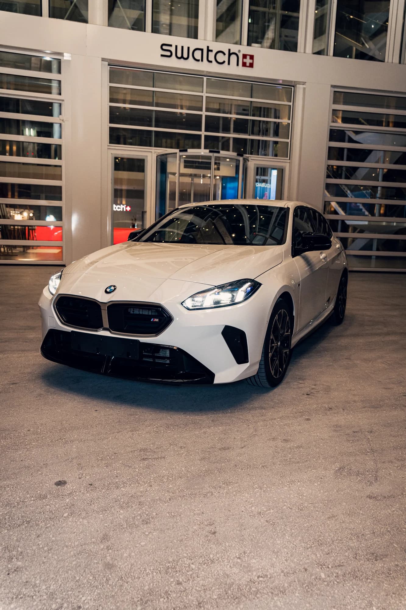BMW M135 blanche de trois quarts avant, de nuit