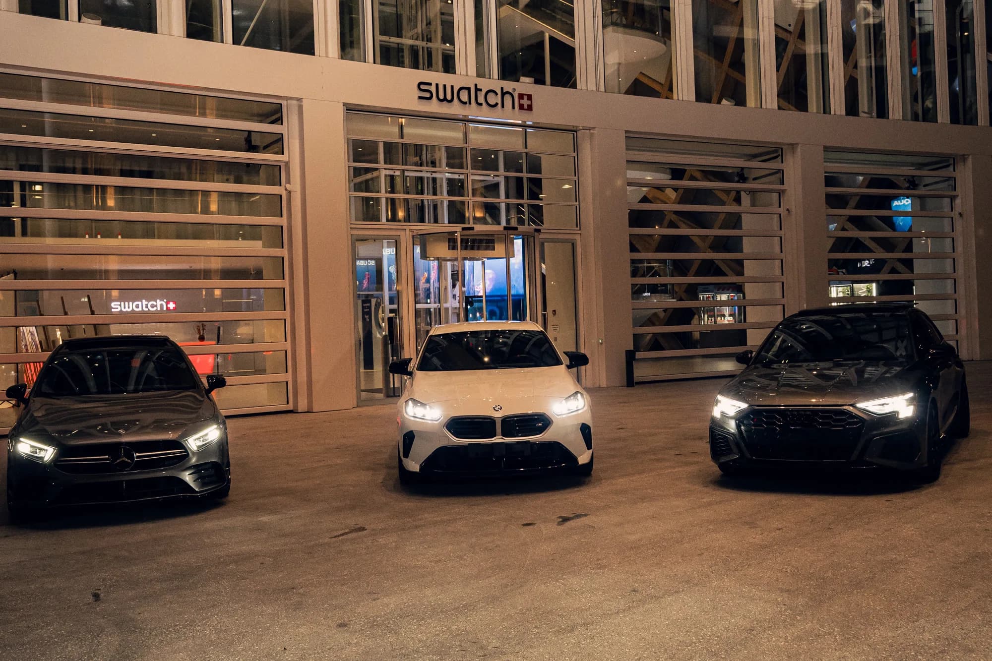 Mercedes-AMG A35, BMW M135 et Audi S3 ABT réunies devant le bâtiment Swatch